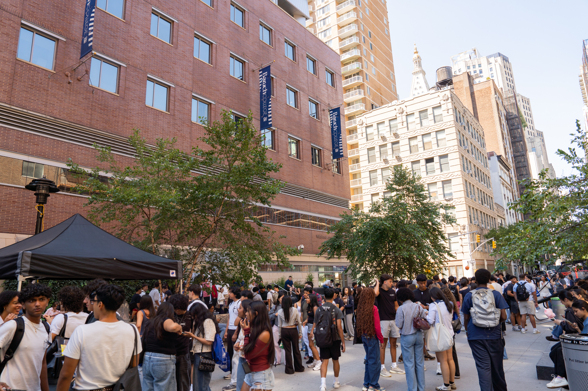 Baruch College students gather on the 25th Street pedestrian plaza outside the Newman Vertical Campus in Manhattan